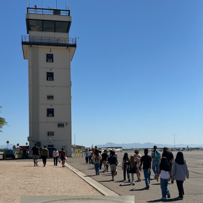 School kids walking on the runway toward airport control tower