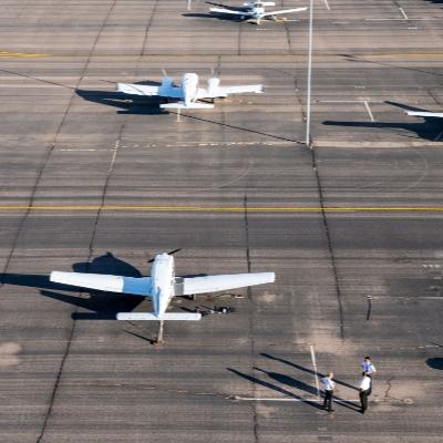 Small group of people standing next to parked planes