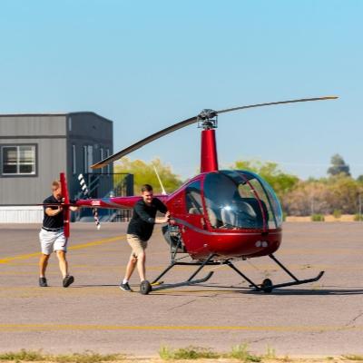 Two people pushing a helicopter
