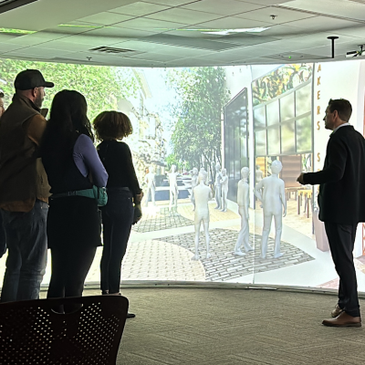 Small group of people in front of large screen at immersion lab