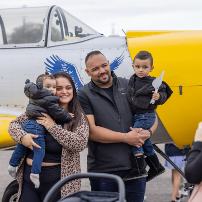 Family taking a photo in front of a plane