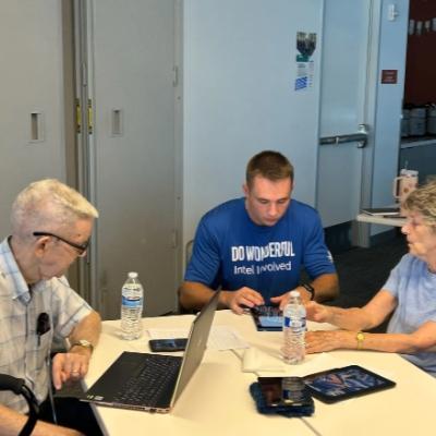 man assisting elderly with technology