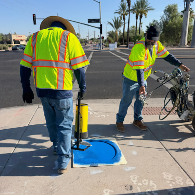 Traffic operations team painting the sidewalk with a blue circle