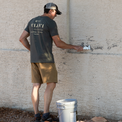 For Our City Day Volunteer Prepping a wall to paint