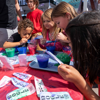 a group of young kids experimenting at a booth at the 2026 CIF