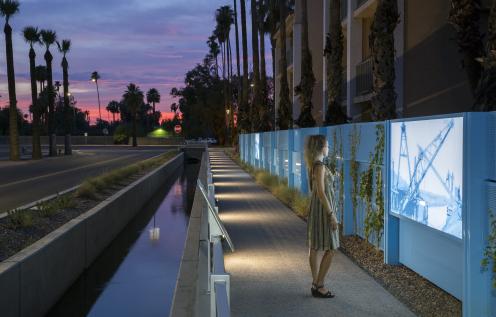 Woman overlooking the Commonwealth Canal in Downtown Chandler at sunset Woman overlooking the Commonwealth Canal in Downtown Chandler at sunset
