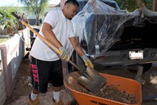 Resident using a shovel and wheelbarrow as part of the Neighborhood Cleanup Program Resident using a shovel and wheelbarrow as part of the Neighborhood Cleanup Program
