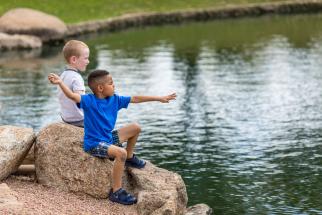 boys skipping rocks by the lake