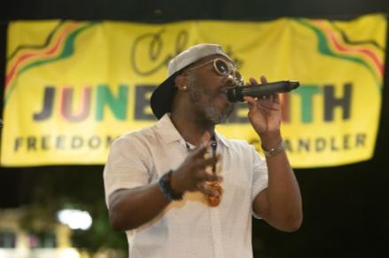 Vaughn Willis performing in front of Juneteenth banner