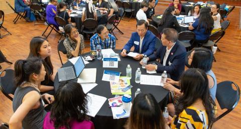 Group of Asian Americans sitting at a round table conversing