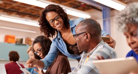 Female helping senior residents with tech questions