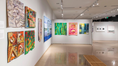 Colorful art quilts on wall at gallery