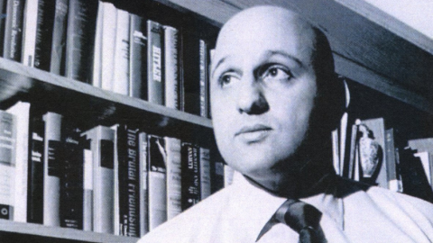 Eddie Basha from the chest up in front of a book shelf