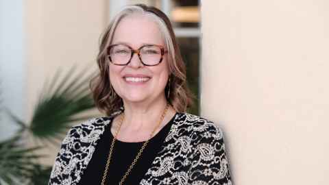 Michelle Mac Lennan standing in front of a tan wall