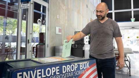Man dropping voted ballot at Chandler City Hall in drop off box