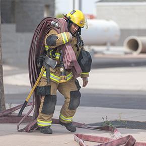 Chandler Firefighter pulling hose.