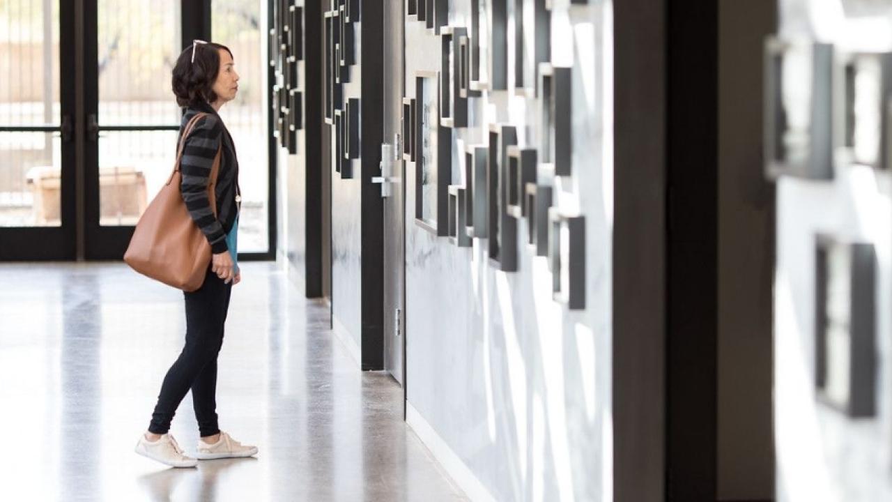 Museum-goer viewing images on display.