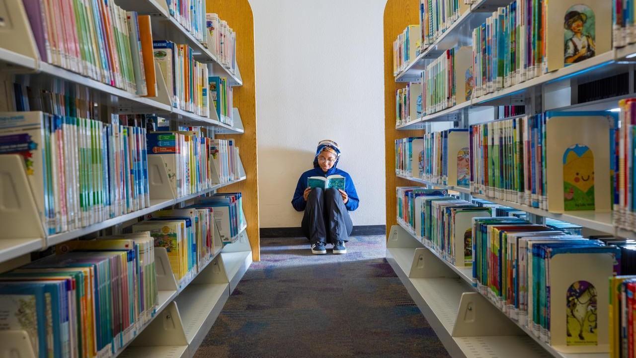 teen reading at library