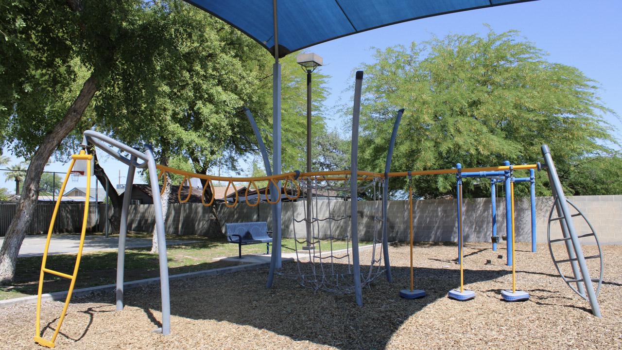 Play structure with monkey bars and climbing features at Pueblo Alto Park