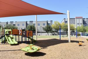Playground with swing sets, spinner, and play structure at Harris Park