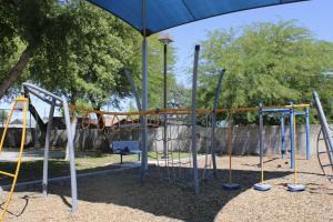 Play structure with monkey bars and climbing features at Pueblo Alto Park
