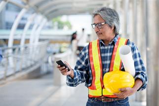 Construction professional holding a cell phone
