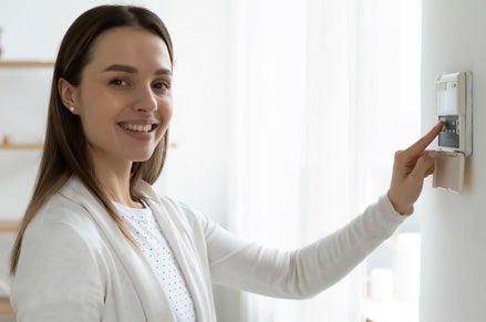 Woman checking her home alarm system